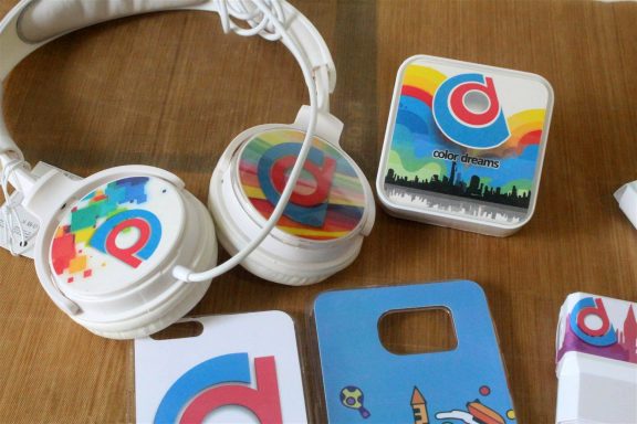 Colourful headphones and various branded cards on a wooden surface.