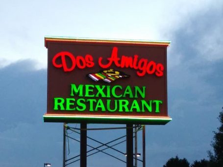 Sign for Dos Amigos Mexican Restaurant with colourful text and symbols of Mexican cuisine.