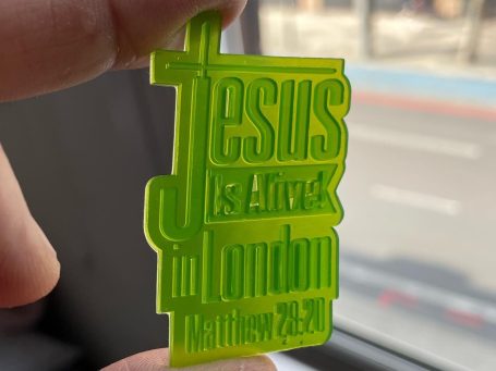 Neon green pendant featuring the text "Jesus is Alive in London, Matthew 28:20.